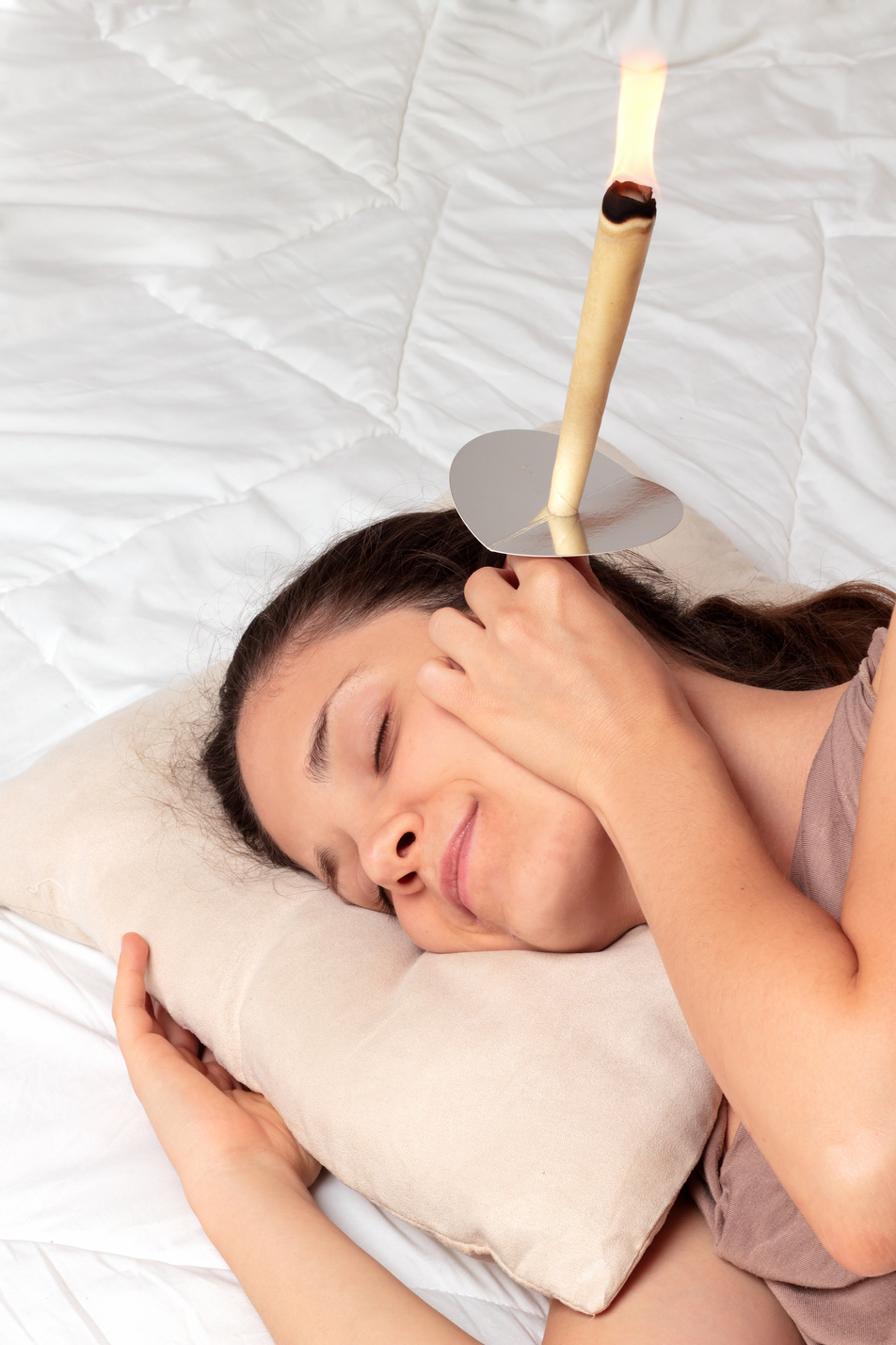 Woman having with ear candle treatment